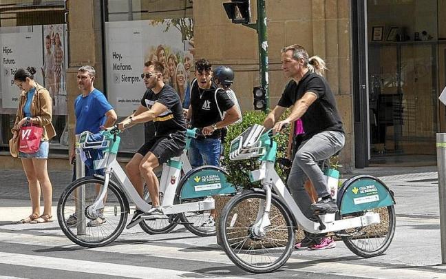 Dos usuarios de la red de alquiler de bicis eléctricas de Pamplona cruzan la calle Cortes de Navarra. | FOTO: PATXI CASCANTE Dos usuarios de la red de alquiler de bicis eléctricas de Pamplona cruzan la calle Cortes de Navarra. | FOTO: PATXI CASCANTE