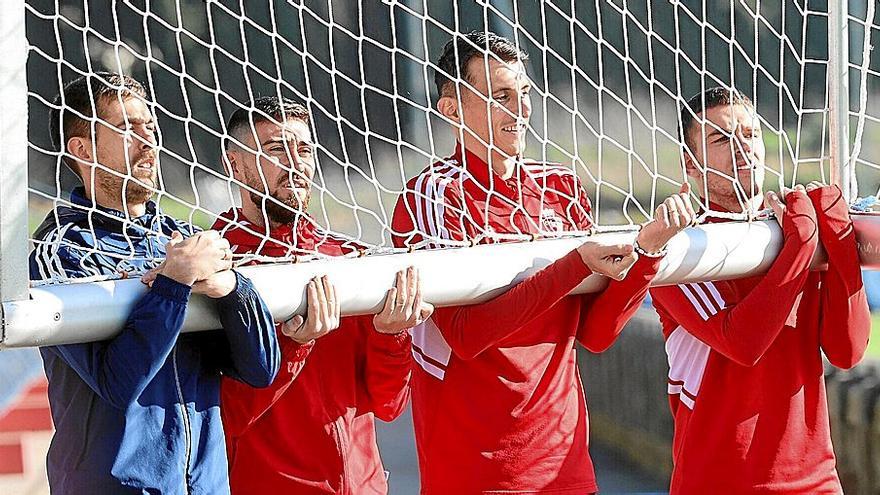 De izquierda a derecha, Aitor Fernández, Moi Gómez, Ante Budimir y el canterano Diego Moreno, cargando ayer con un portería en las instalaciones de Tajonar.