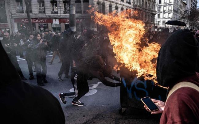 Un hombre quema un contenedor en la tercera jornada de protestas en Lyon.