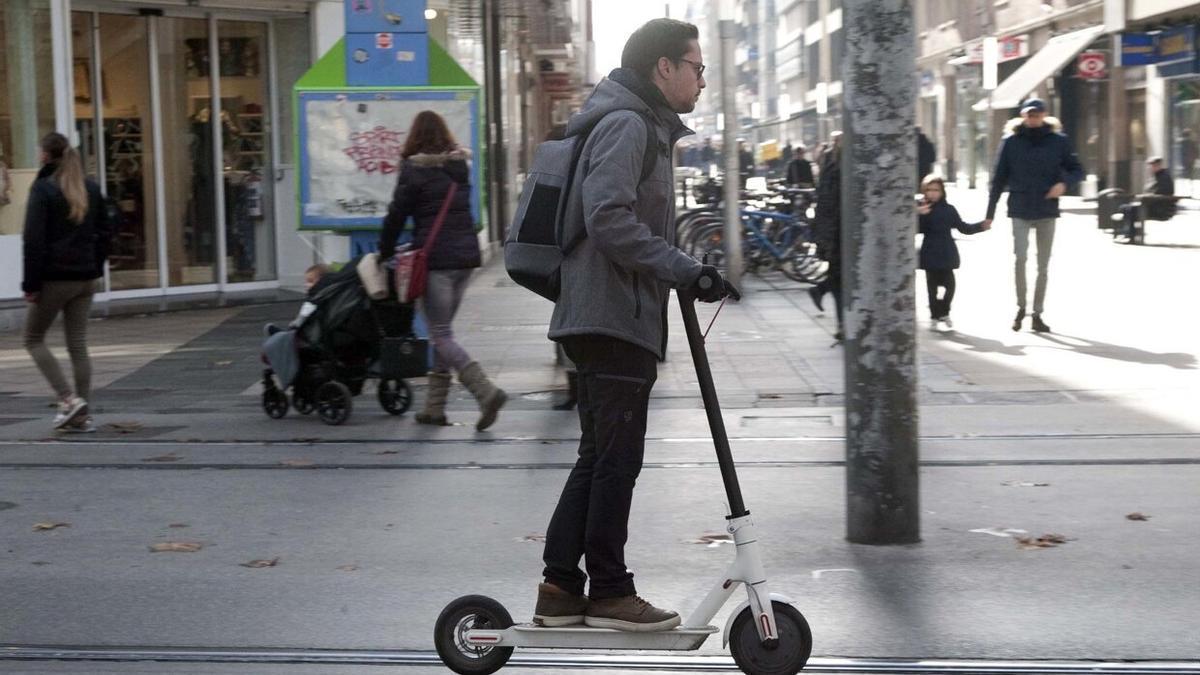 Un joven ajeno a esta información se desplaza en patinete por Vitoria.