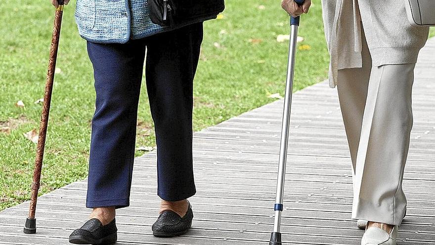 Dos mujeres de la tercera edad caminan juntas apoyándose en un bastón. Foto: Josu Chavarri Erralde