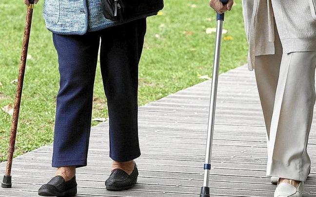 Dos mujeres de la tercera edad caminan juntas apoyándose en un bastón. Foto: Josu Chavarri Erralde