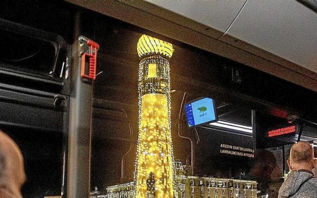 Un señor y su acompañante contemplan las luces del puente de la Zurriola desde el autobús.