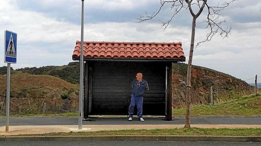 Un vecino de la zona alta de Meatzaldea espera al bus en la iluminada marquesina de Triano. | FOTO: E. ZUNZUNEGI