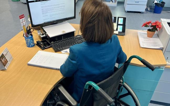 Una empleada en silla de ruedas en su puesto de trabajo. Una empleada en silla de ruedas en su puesto de trabajo.