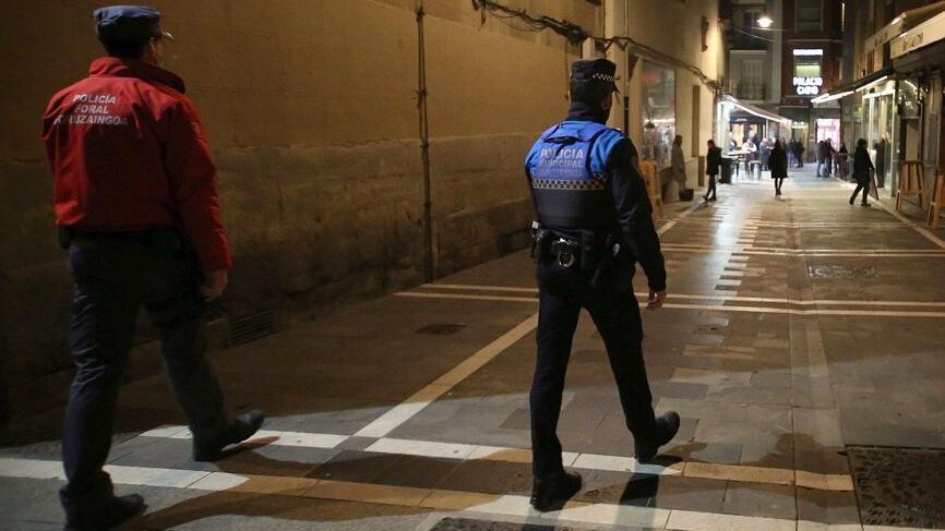 Un policía municipal y un policía foral patrullan por el Casco Viejo.