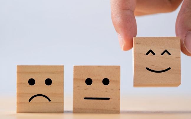 Tres peque&ntilde;os cubos de madera reflejan distintos estados de &aacute;nimo.