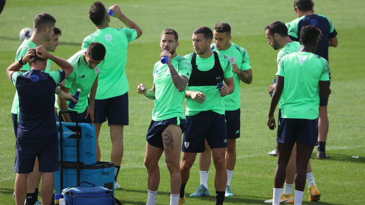 Iñigo Martínez, rodeado de sus compañeros, se hidrata durante un entrenamiento en Lezama.