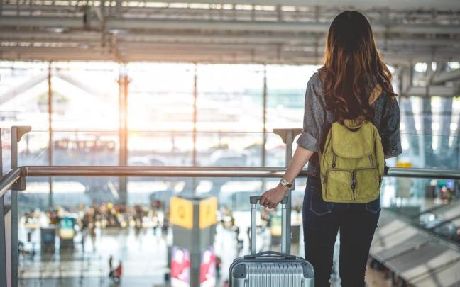 Una mujer se va de viaje con una pequeña mochila en la espalda. Una mujer se va de viaje con una pequeña mochila en la espalda.
