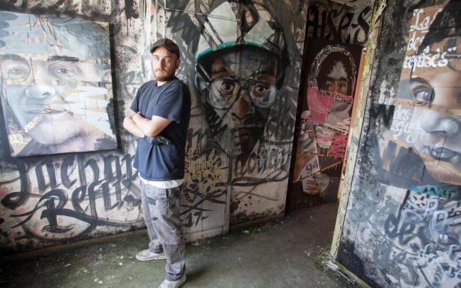 Asier Vera posa junto a unos murales que pintó en Francia.