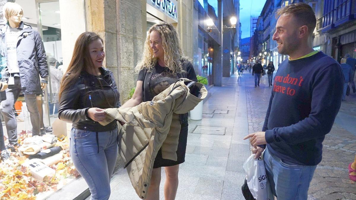 Dos turistas gaditanos se interesan por una prenda de abrigo en una de las tiendas de ropa más emblemáticas de las Siete Calles.