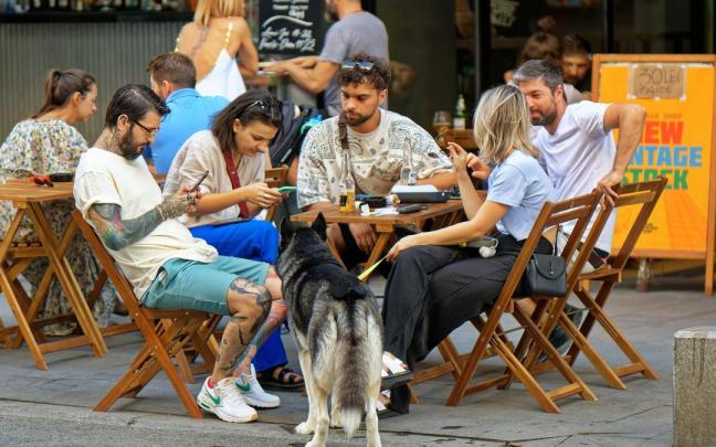 Turistas usan sus teléfonos en un restaurante. Turistas usan sus teléfonos en un restaurante.
