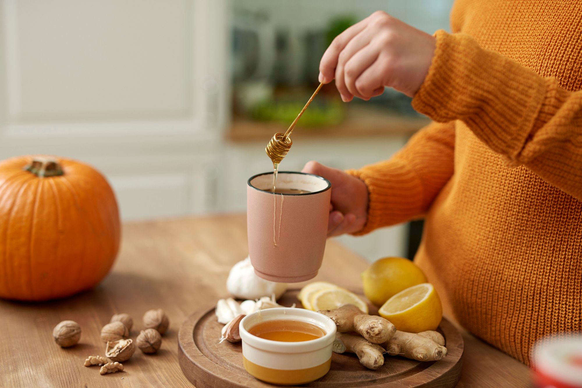 Una mujer prepara un té con miel.