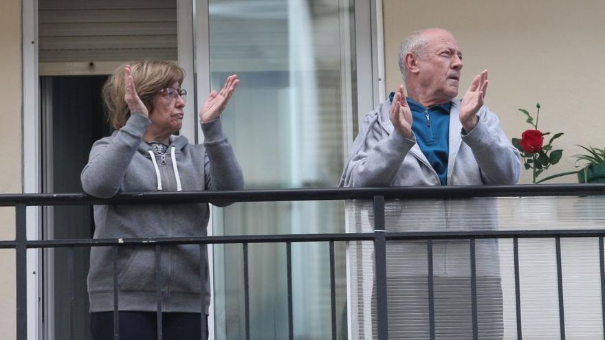 Dos personas aplauden al personal sanitario durante el confinamiento