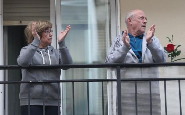 Dos personas aplauden al personal sanitario durante el confinamiento