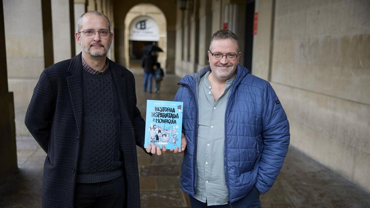 Joseba Beramendi y Javier Traité, autores de ‘Historia disparatada de la monarquía’, posan con un ejemplar de su libro en la Plaza del Castillo.