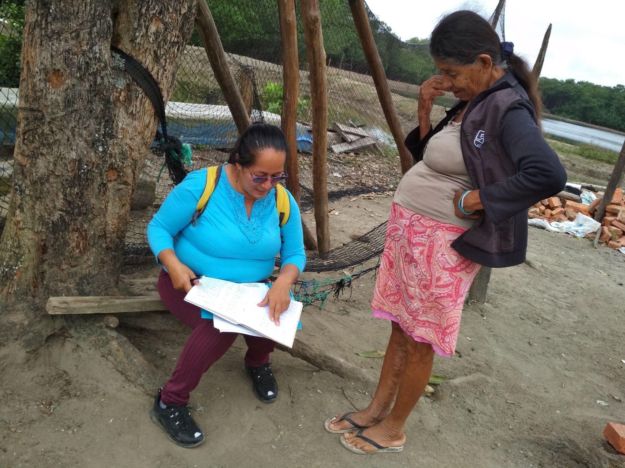 Ketty le recuerda a doña María, vecina de Colorado (Cojimíes), cómo escribir su nombre.