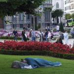Una persona descansando en una zona ajardinada del centro de Bilbao.