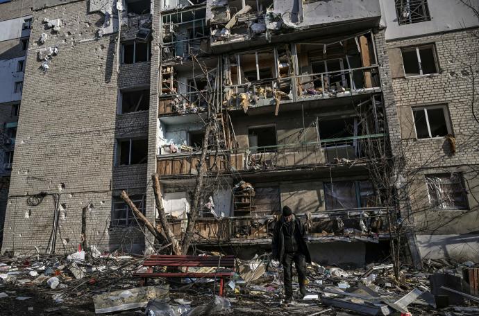 Un hombre camina frente a un edificio de apartamentos destruido por los bombardeos en Kharkiv.