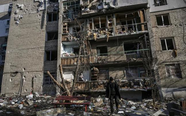 Un hombre camina frente a un edificio de apartamentos destruido por los bombardeos en Kharkiv.