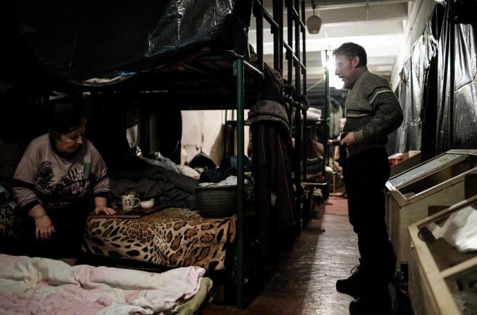Una madre y su hijo hablan en sus literas en el búnker de la fábrica Ostchem, en el este de Ucrania.