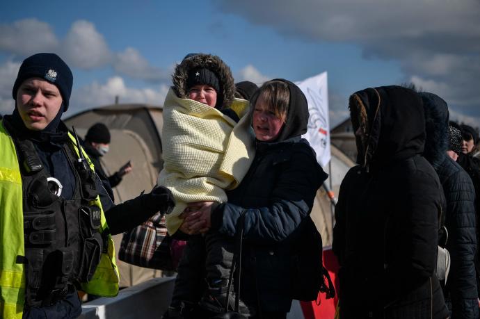 Una mujer con su hijo después de cruzar la frontera entre Ucrania y Polonia, en el cruce fronterizo de Medyka.