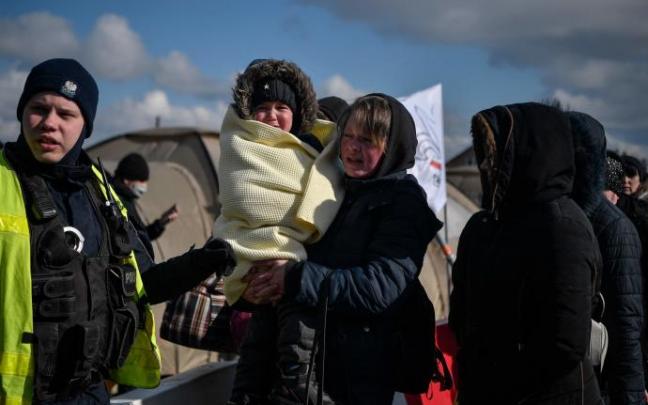 Una mujer con su hijo después de cruzar la frontera entre Ucrania y Polonia, en el cruce fronterizo de Medyka.