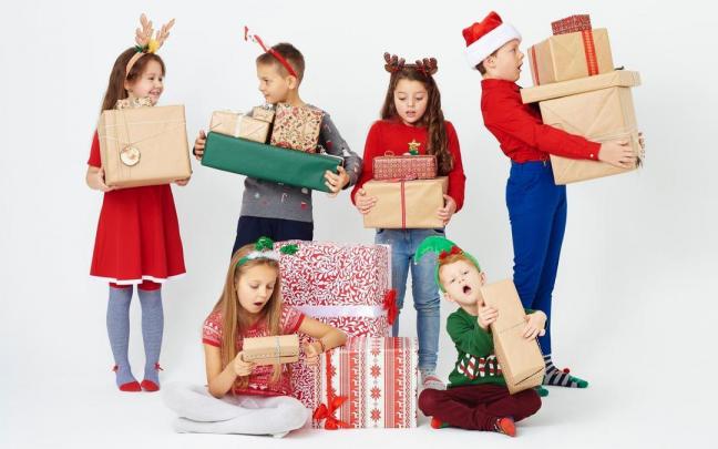 Un grupo de ni&ntilde;os y ni&ntilde;as con los regalos navide&ntilde;os.