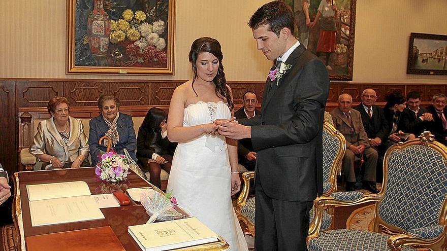 Una pareja de novios se entrelaza los anillos durante una de las bodas civiles celebradas en la sala de recepciones del Consistorio vitoriano. | FOTO: DNA