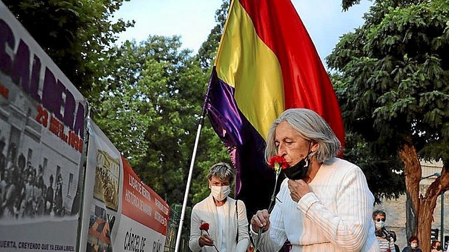 Una mujer deposita una rosa en el homenaje de 2021.