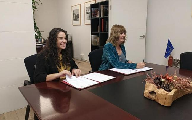 Ana Ollo y Amaia Cunchillos firmando el convenio.