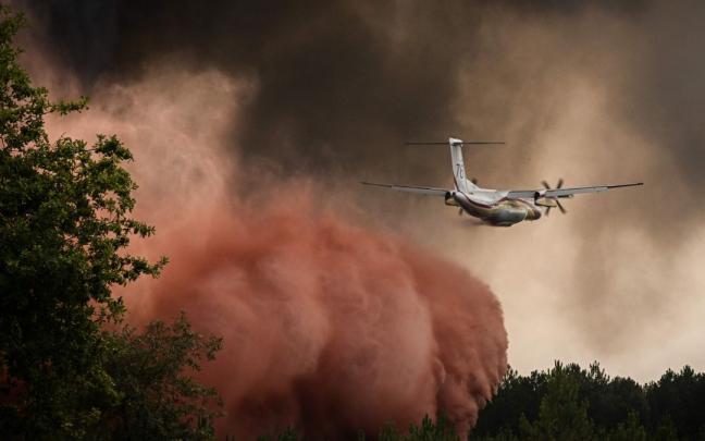 Un avi&oacute;n colabora en las labores de extinci&oacute;n del incendio en Gironda, Francia.