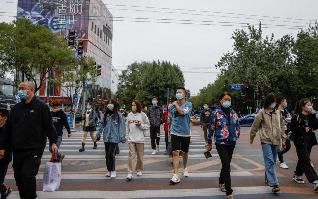 Varias personas caminan por Pekín.