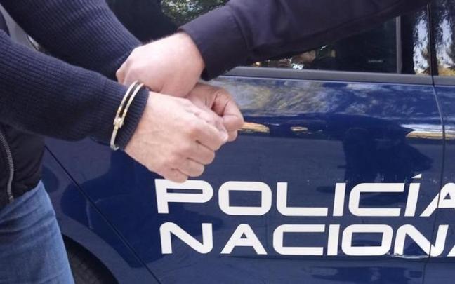 Un hombre es esposado y conducido por un agente de policía. Un hombre es esposado y conducido por un agente de policía.