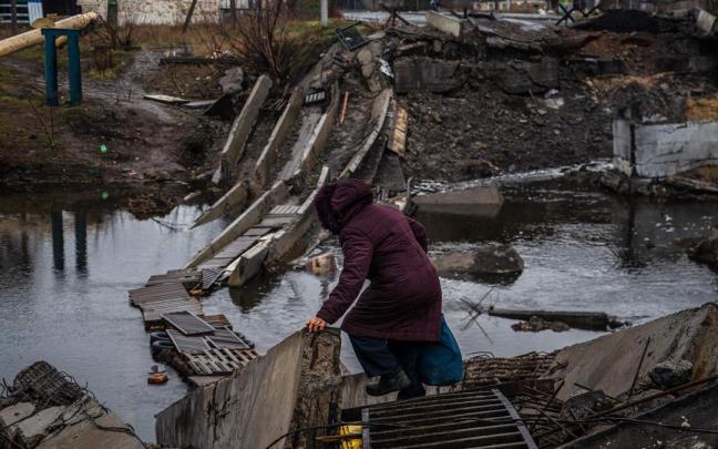 Una mujer trata de cruzar por un puente destruido en la ciudad de Bakhmut, en la región de Donetsk. Una mujer trata de cruzar por un puente destruido en la ciudad de Bakhmut, en la región de Donetsk.