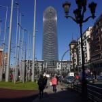 Varios viandantes pasan por las inmediaciones de la Torre Iberdrola.