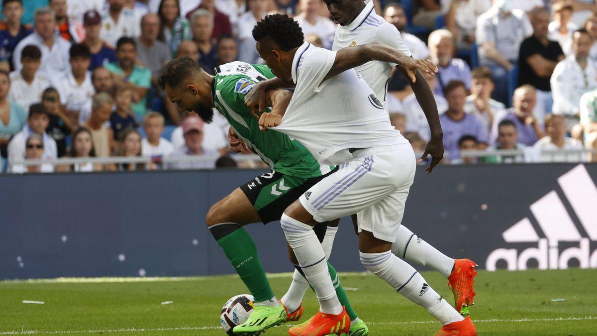 El bético Borja Iglesias se protege ante el madridista Militao.