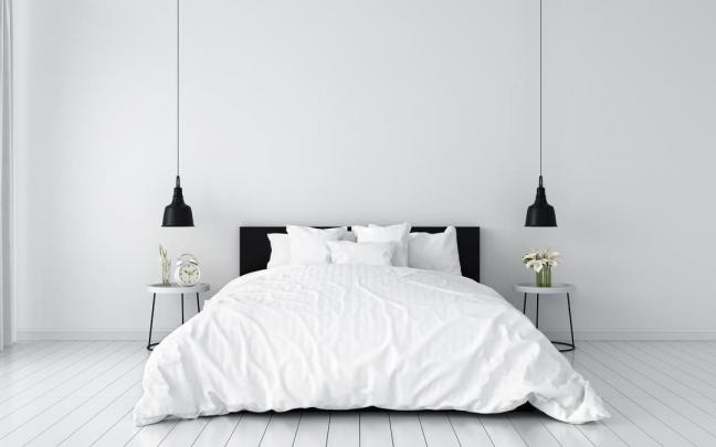 Habitación minimalista con una cama con edredón nórdico.