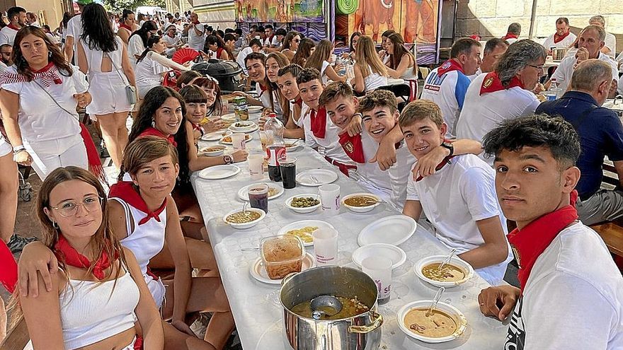 Una cuadrilla de jóvenes del municipio, con los platos llenos de pochas a punto de empezar a comer.