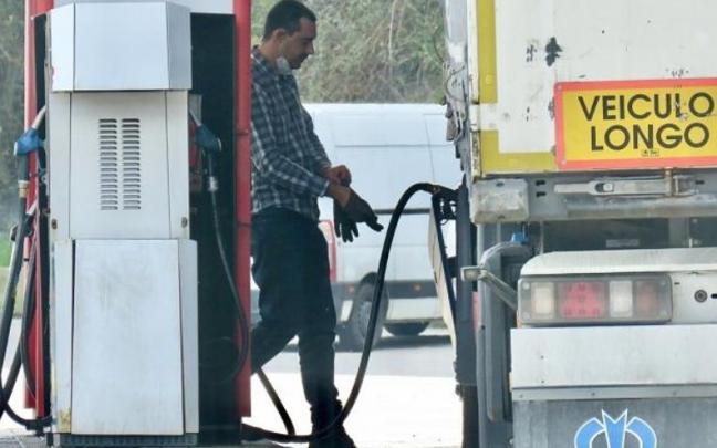 Un transportista llena el depósito de su vehículo.