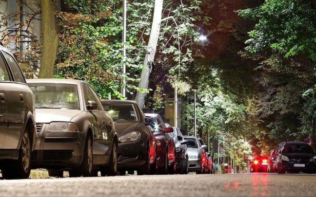 Coches aparcados en paralelo en la calle.