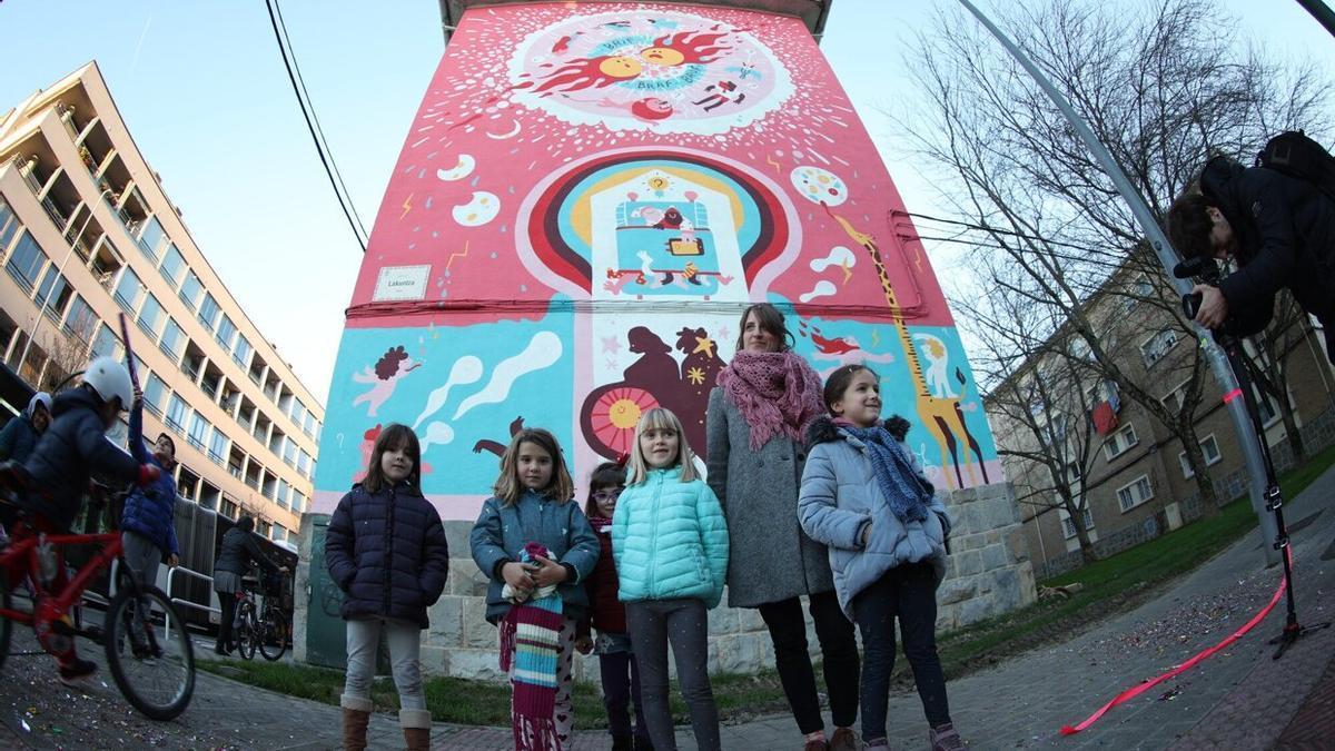 Maite Mutuberria, ante el mural y junto a parte del alumnado del Bernart Etxepare que ha colaborado con ella en su creación.