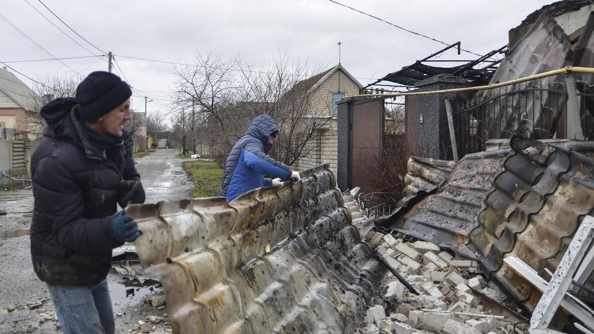 Dos hombres recogen los restos de una casas tras un ataque ruso en Jersón.