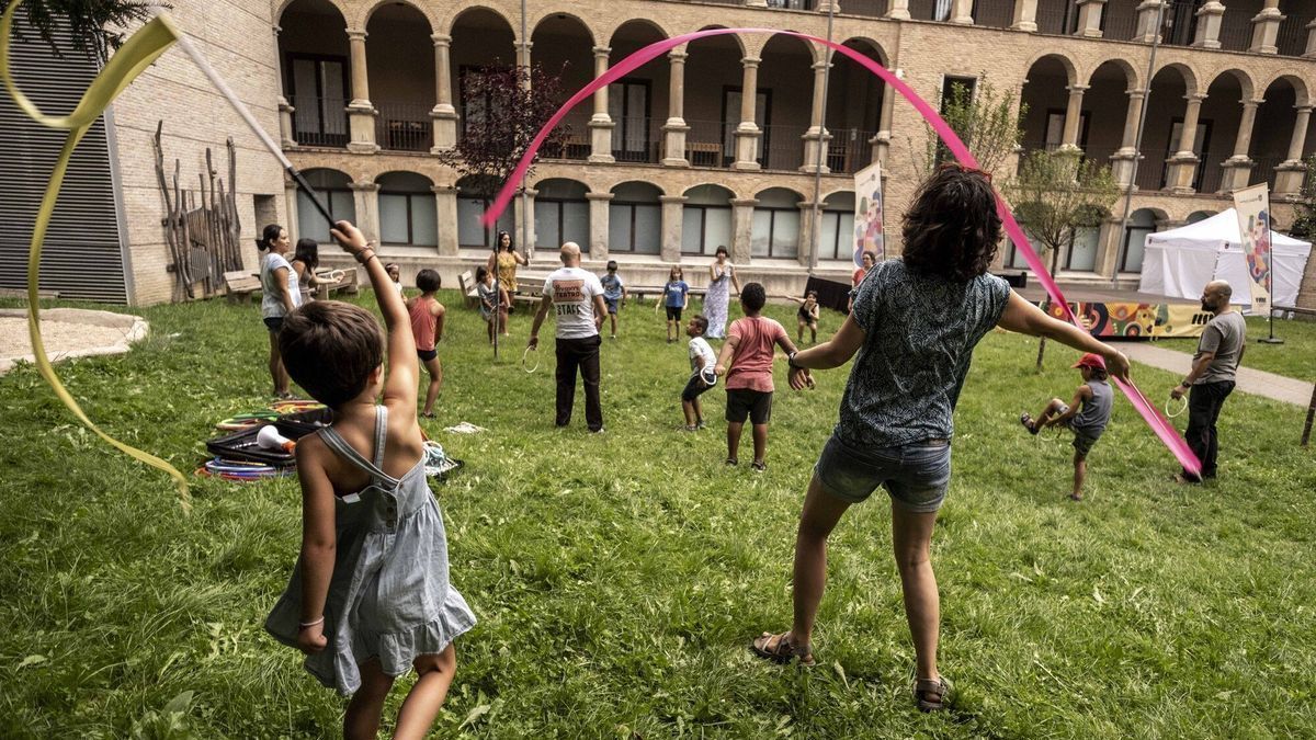 Madre e hija probando algunos de los materiales circenses, mientras el resto siguen las instrucciones del director de la compañía.