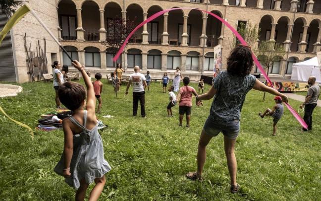 Madre e hija probando algunos de los materiales circenses, mientras el resto siguen las instrucciones del director de la compa&ntilde;&iacute;a.