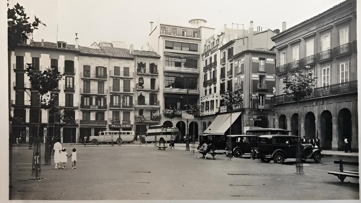 Postal de 1935. Esquina sudeste de la plaza. Desde la izquierda, puede verse el n&uacute;mero 12 y a continuaci&oacute;n las casas con n&uacute;meros 13 y 14 que fueron derribadas para construir el nuevo edificio de Huarte y Compa&ntilde;&iacute;a; en la