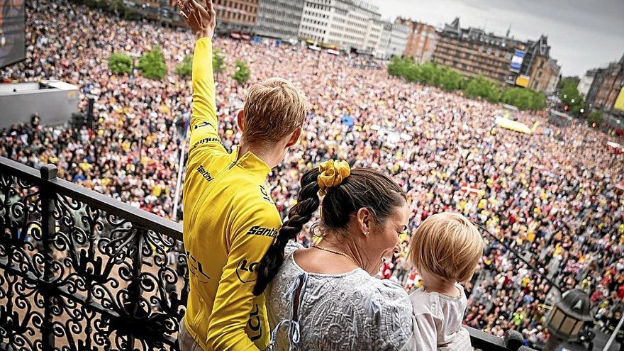 Vingegaard, junto a su mujer y su hija, saluda desde el balcón del Ayuntamiento de Copenhague. | FOTO: EFE