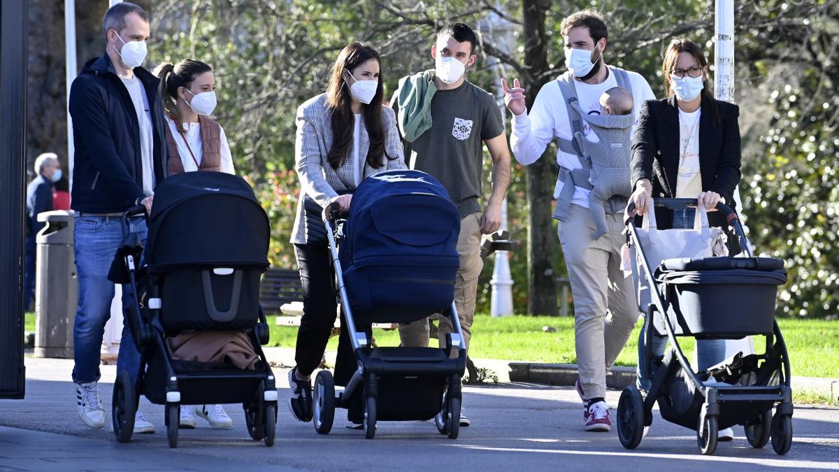 Varias familias paseando juntas con sus carritos de bebé en el Parque de Doña Casilda.