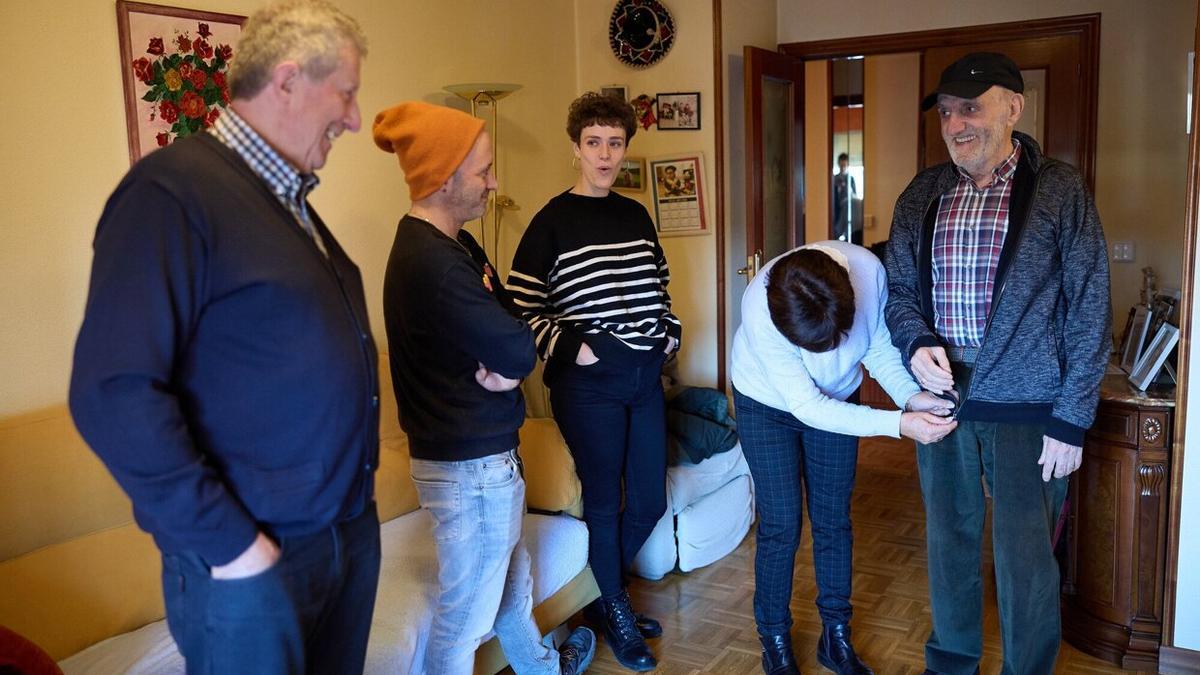 Toñi le abrocha la chaqueta a Javier antes de salir a dar un paseo.