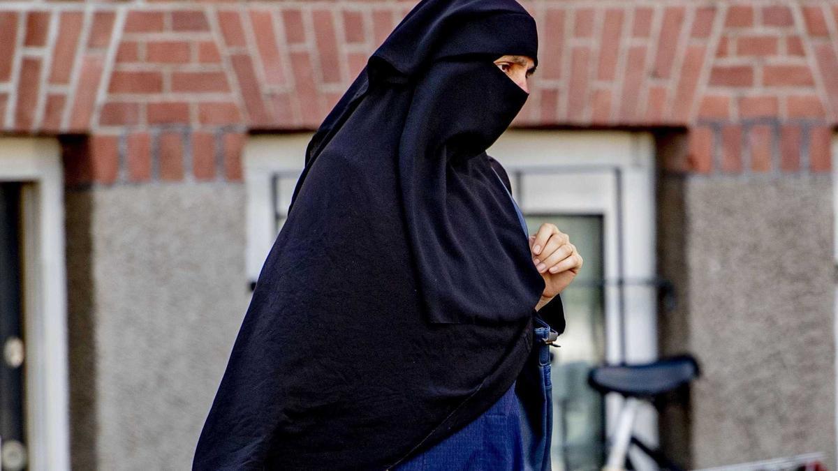 Una mujer pasea con un velo niqab.